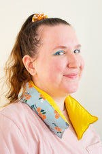 Load image into Gallery viewer, Woman smiles at camera wearing a long and skinny cherry pit grain bag around her neck.
