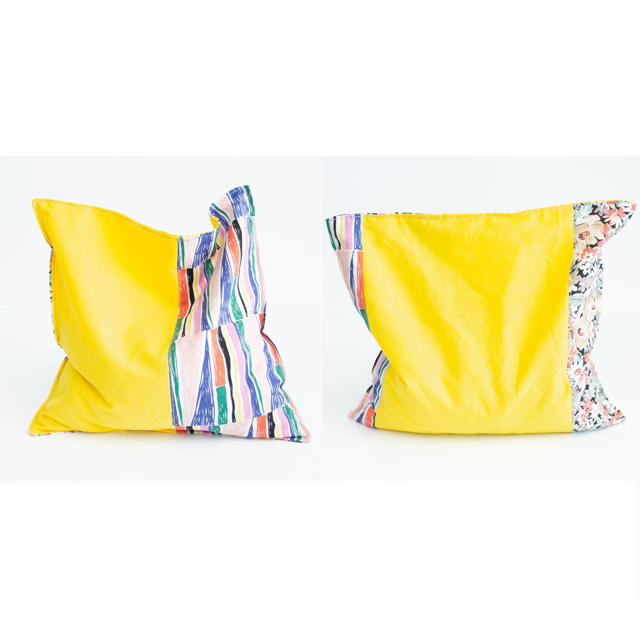 Two grain bags sit side by side showing front and back patchwork patterns. Front and back of patchwork (a mix of a floral print, a geometric print, and solid yellow) rectangle cherry pit grain bag. Sit on white background.
