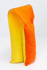 Load image into Gallery viewer, Long and skinny cherry pit grain bag on white background. Half yellow, half orange. 
