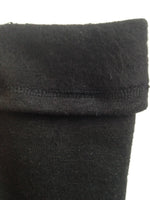Load image into Gallery viewer, A close up of the inside of black fleece leg warmers shows the inside texture to be fuzzy. The outside texture is a smooth knit fabric. 

