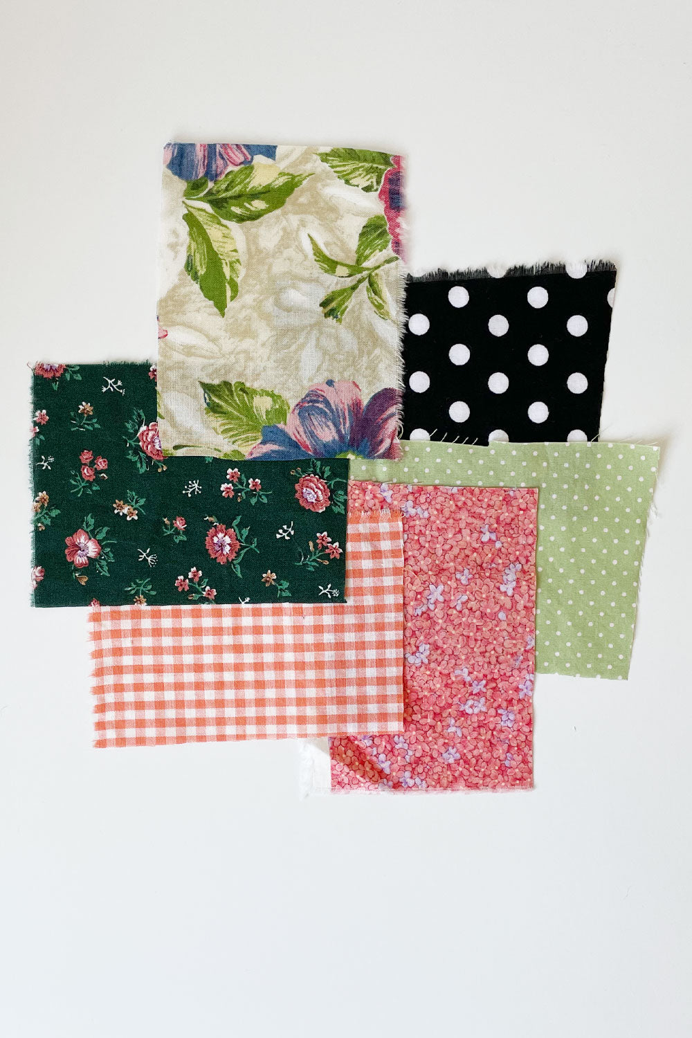 6 small fabric swatches mainly in shades of pink, green, and black/white polka dot..