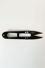 Load image into Gallery viewer, One thread snips lying horizontally. The handles are slightly shiny and black; the blades are dark grey. LDH logo on the top blade. 
