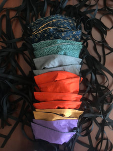 a row of cotton fabric face masks with black ties