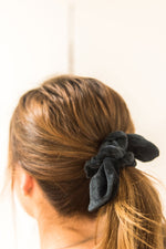 Load image into Gallery viewer, Close up of a woman facing away from camera. Her hair is tied in a mid-ponytail with a black velvet bow hair scrunchie.
