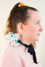 Load image into Gallery viewer, Profile of a smiling woman has a cherry pit grain bag with ties tied around her neck
