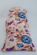 Load image into Gallery viewer, Cotton cherry pit warmer in blue and magenta floral print on pink background. 

