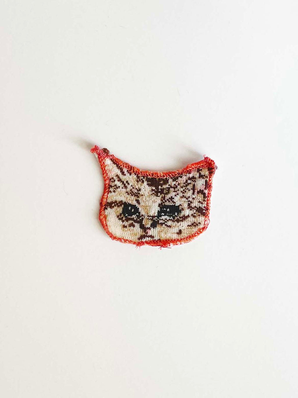 Sad cat head applique on white background. 