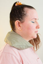 Load image into Gallery viewer, Profile of a woman with eyes closed wears a cherry pit grain bag around her neck.
