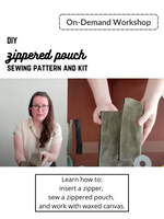 Load image into Gallery viewer, Woman holds zippered pouch to above camera. On-demand workshop. DIY zippered pouch sewing pattern and kit. Learn how to: insert a zipper, sew a zippered pouch, and work with waxed canvas.
