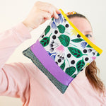 Load image into Gallery viewer, Woman holds a cherry pit grain bag covering most of her face except one eye.
