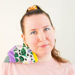 Load image into Gallery viewer, Smiling woman looks into camera. A rectangle cherry pit grain bag sits on her right shoulder. 
