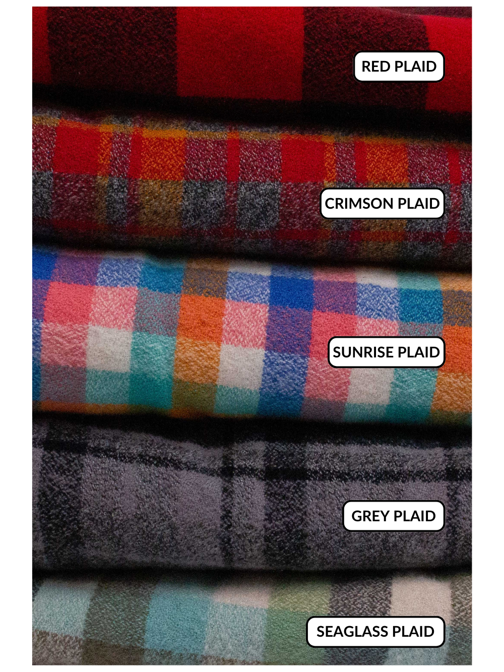 All of the plaid fabrics in a stack: Red plaid: large buffalo plaid in red and black. Crimson plaid: small plaid in shades of red, orange, and grey. Sunrise plaid: small plaid with pinks, oranges, blues, and teal greens. Seaglass plaid: larger plaid with greens, light blue, and grey. Grey plaid: small plaid with greys and black. 