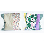 Load image into Gallery viewer, Two grain bags sit side by side showing front and back patchwork patterns. Front and back of patchwork (floral prints and solid sage green, yellow and purple) rectangle cherry pit grain bag. Sit on white background.
