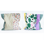 Load image into Gallery viewer, Two grain bags sit side by side showing front and back patchwork patterns. Front and back of patchwork (floral prints and solid sage green, yellow and purple) rectangle cherry pit grain bag. Sit on white background.
