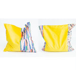 Load image into Gallery viewer, Two grain bags sit side by side showing front and back patchwork patterns. Front and back of patchwork (a mix of a floral print, a geometric print, and solid yellow) rectangle cherry pit grain bag. Sit on white background.
