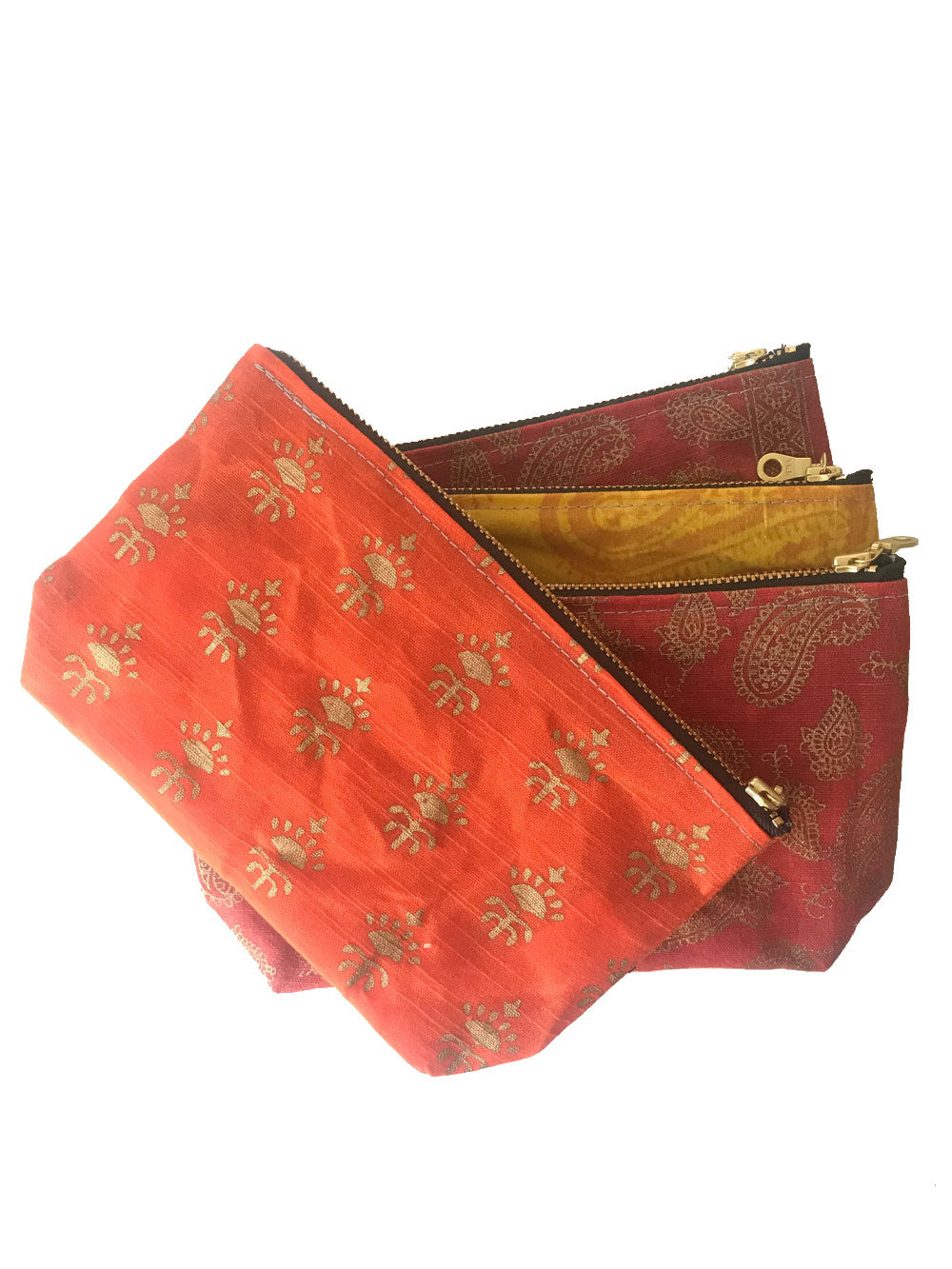 A stacked fan of waxed zippered pouches with brass zippers. From the bottom: red, yellow, red, and orange.