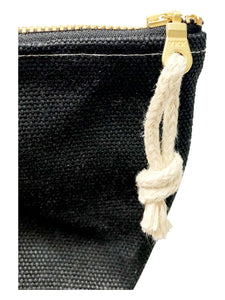 A close up of a black waxed canvas pouch with hemp zipper pull tied through the zipper pull. 
